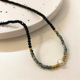 Elegant Black Bead Necklace Adorned with Gold and Pearls